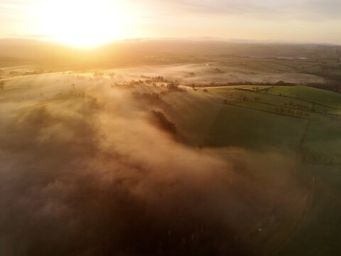 Hills countryside sunrise in morning fog - Arial drone view