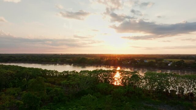 Drone footage over San Jos&eacute; del Guaviare, Colombia, capturing dense rainforest canopy, riverbanks, and a crossing point within the remote jungle scenery.