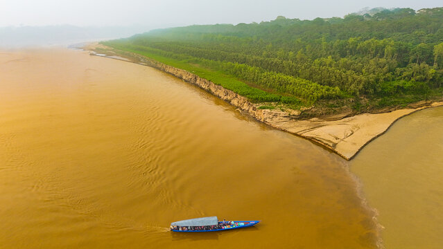 Aerial view of the confluence of two mighty rivers, where ochre waters meet beneath a verdant canopy, Puerto Maldonado, Madre de Dios, Peru.