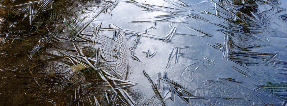 Close-up of ice patterns forming on a shallow body of water, creating a textured, crystalline surface. Adamello Brenta Natural Park, Madonna di Campiglio,Trentino,Italy