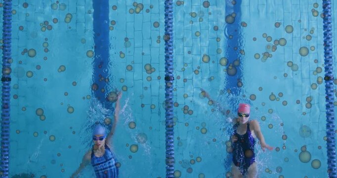 Vertical video: Arms entering top starting two swimmers training backstroke in pool lane rope, caps