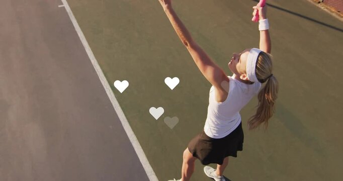 Serving woman tennis player swinging racket tossing ball on hardcourt headband, hearts, copy space