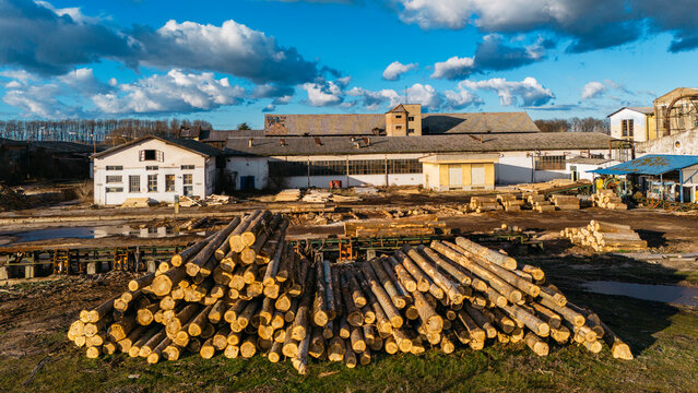 Aerial view of sun-kissed logs contrast against the aged industrial buildings, evoking a sense of history and industry, Sremska Mitrovica, Vojvodina, Serbia.