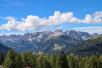 White cumulus clouds hugging mountain tops