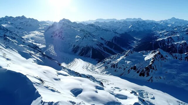 Vast snow covered mountain range and high peaks, immense glaciers flow through deep valleys. Breathtaking cold winter alpine landscape