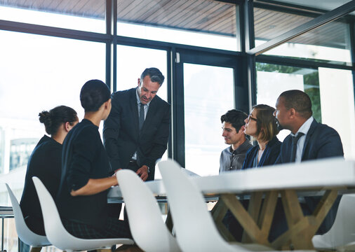I just wanna pass out some documents to everyone. Cropped shot of a diverse group of businesspeople having a meeting in a boardroom.