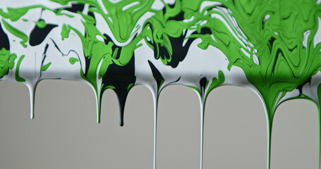 Fototapeta premium Close up of black, green and white paint flowing down a pane of glass against a soft grey background, creating a minimalist abstract texture for design and advertising uses.