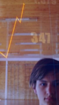 Vertical video: Cam tilting down showing teen holding basketball, graph overlaying him for sports