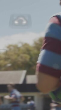Vertical video: Rugby player catching ball as ball enters securing for drill AR icons over arm