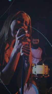 Vertical video: Hands on mic sparking reveal, singer singing to project, music visuals passing band