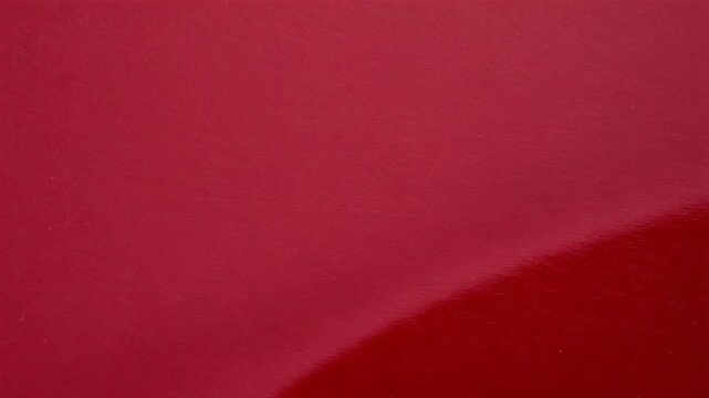 Luxury dark red paper texture with smooth glossy surface and diagonal shadow separation for elegant minimalist background designs