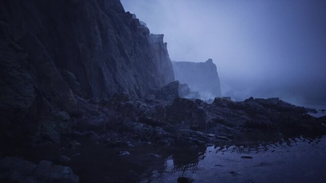 predawn rocky coastline bathed in deep blue, calm sea reflecting indigo sky, smooth pebbles on shore, distant cliffs fading into mist, tranquil serene panorama
