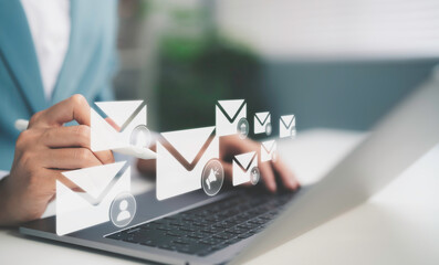 Fototapeta premium Businesswoman using stylus on laptop with floating email icons representing email marketing communication digital messaging customer engagement online campaign strategy and business connection