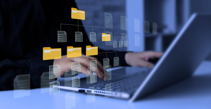 Digital file organization concept with connected folders, online database, workflow automation and cloud data. Business professional working on laptop with virtual document management system interface