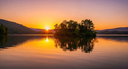 Obraz premium A serene lake at sunset with a small island and trees in the background