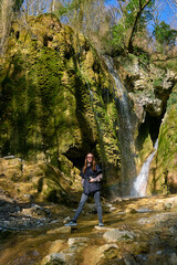girl on the background of a large beautiful waterfall in the gorge