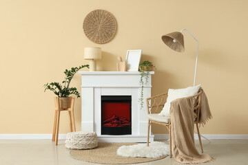 Naklejka premium Fireplace, wicker chair and houseplants in interior of living room