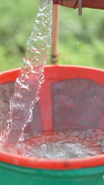 Farmer mixing water in pesticide or fertilizer powder at agriculture field 