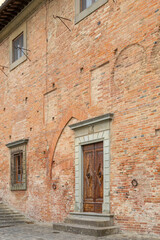 Fototapeta premium Old brick building with historic door in San Miniato