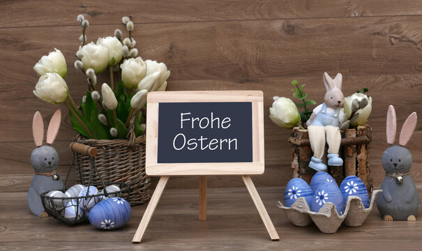 Osterkarte Frohe Ostern. Ein Strau&szlig; Tulpen, Osterhasen und Ostereier mit dem Text Frohe Ostern auf einer Tafel.