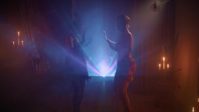 Blue orange color neon light, dark black silhouette two happy woman dancing in night club. Sexy joy girls flapper female have fun at dance floor retro party new year 1920s old style roaring twenties
