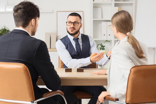 Male business mediator working with clients at table in office