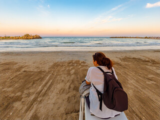 Woman traveler watching sunset on Black Sea beach in Saturn resort Romania © Dan Badiu