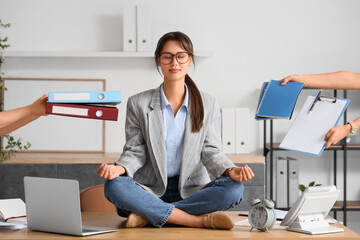 Young businesswoman with a lot of work meditating at her workspace in office. Deadline concept