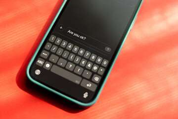 Obraz premium Smartphone message keyboard screen are you ok emotional support mental health check-in friendship concern caring digital communication social connection