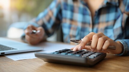 Fototapeta premium Woman accountant use calculator and computer with holding pen on