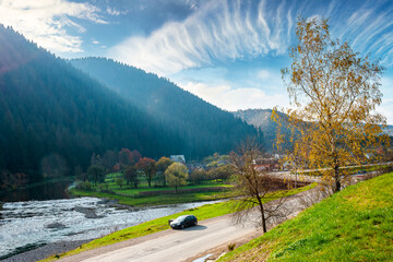 Naklejka premium mountain landscape during fall season. rural scenery of transcarpathia with rika river in the afternoon light. picture of a countryside road through valley near soimy village for travel background