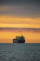 Fototapeta premium Stock images of Ship carrying containers with crude oil barrels from the harbour. Ship blocked in harbour.