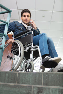 conceptual photo of businessman on wheelchair in front of stairs