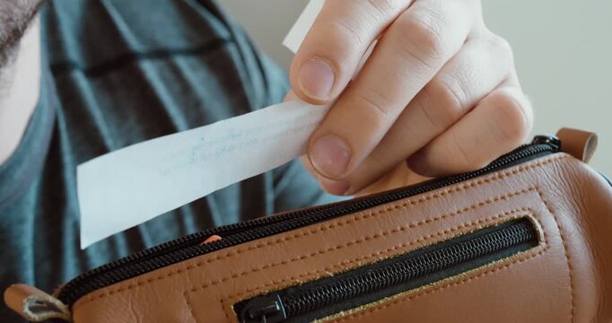 Close-up of a student pulling a hidden cheat sheet from a pencil case during an exam. Concept of cheating in school, test fraud, academic dishonesty, and secret notes.