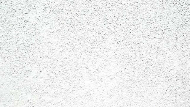 Closeup of a white textured wall ideal for backgrounds and overlays showcasing a clean bright surface with subtle rough details.