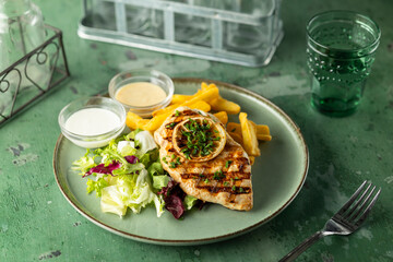 Grilled chicken breast with french fries and salad