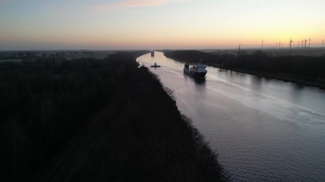 Schiffe fahren bei Sonnenaufgang durch den Nord-Ostsee-Kanal