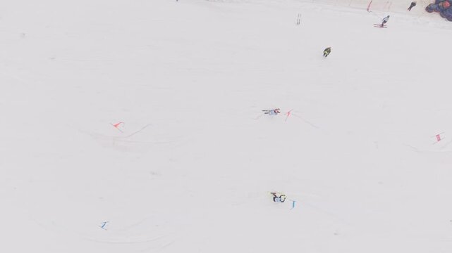 Top view drone shot of two skiers racing parallel slalom on snowy competition slope