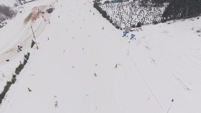 Top view drone shot of two skiers racing parallel slalom on snowy competition slope