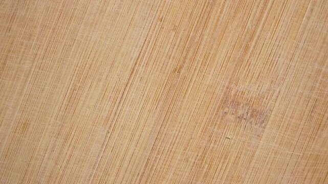 Rotating bamboo cutting board texture with natural grain pattern