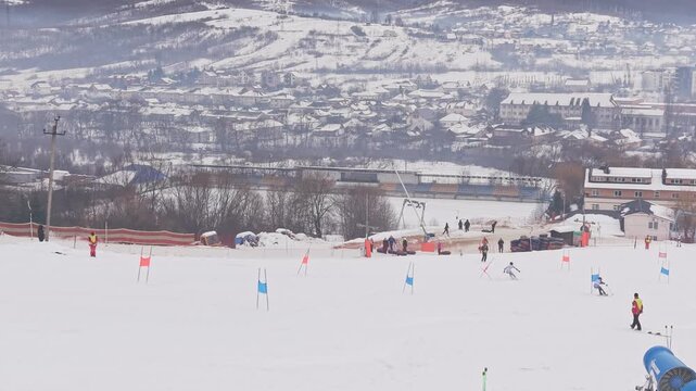 Drone following two skiers racing parallel slalom on snowy mountain competition slope