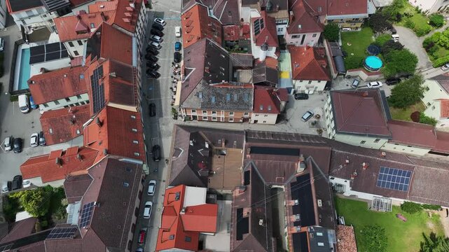 Summer drone footage showing medieval Friesach, old fortified walls, rooftops, towers, hills, serene atmosphere, warm daylight, gentle cinematic motion