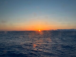 Obraz premium Beautiful Sunrise over the Horizon of Vast Ocean from Ship Deck
