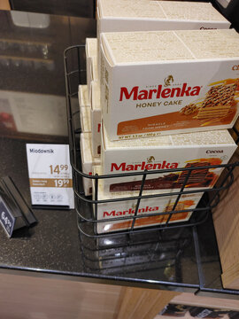 Boxes of Marlenka honey cakes displayed in a wire basket on a store shelf