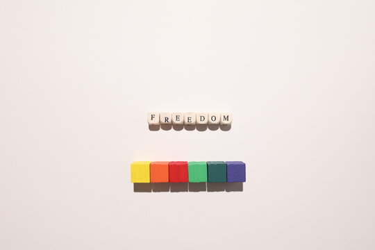 &ldquo;Freedom&rdquo; spelled above rainbow blocks on white background symbolizing equality, inclusion, human rights and LGBTQ pride.