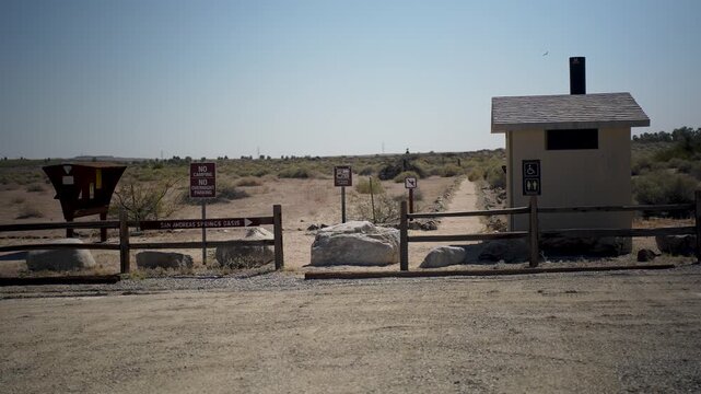 The Dos Palmas oasis restroom and parking lot in Californias Salton Sea area with its signs and conservation efforts in the desert.