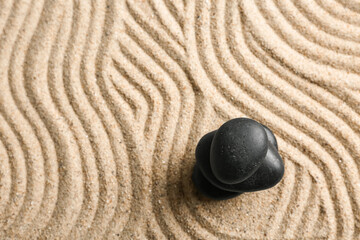 Black stones on sand with lines. Zen concept