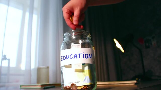 Saving for education fund using money jar. Young person carefully placing money into labeled Education savings jar. Perfect for student finance, parental planning, and investment in knowledge themes