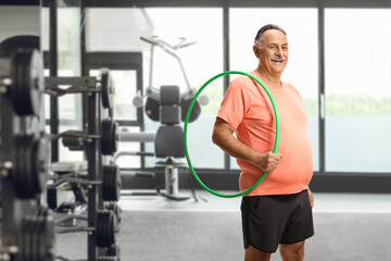 Senior man in a gym holding a hula hoop