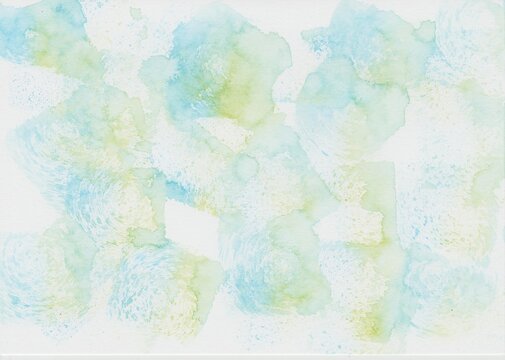 A watercolor background dabbed with a sponge in light blue and light green